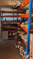 Dans un garage en face : deux minis-racks porteurs bleus et …
