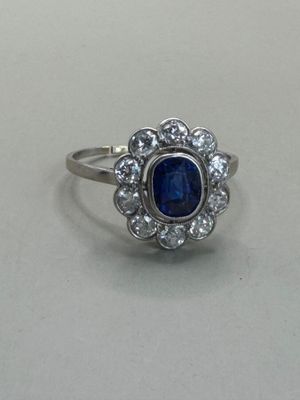 a close up of a blue sapphire and diamond ring on a table