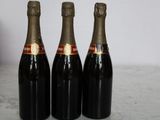 three bottles of wine sitting on top of a table next to a box