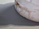a white statue of a baby on a table next to a toothbrush