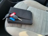 un portefeuille et des clés de voiture sur la banquette arrière d'une voiture