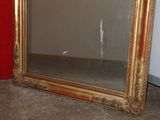 a mirror that is sitting on the floor next to a red wall