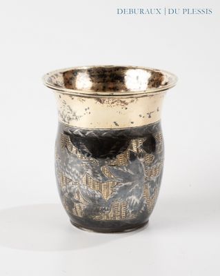 a black and gold vase sitting on a white surface