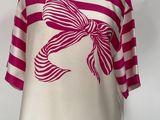 pink and white striped shirt with a bow on a mannequin