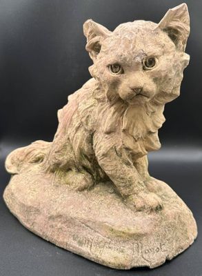 un gros plan sur la statue d'un chat assis sur un rocher