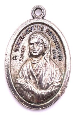 un gros plan d'une médaille en argent sur laquelle figure une image de Jésus