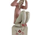 une figurine représentant une femme assise sur une boîte