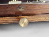 a close up of a clock on a wooden shelf