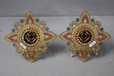 une paire de boucles d'oreilles dorées ornées de pierres multicolores et de perles