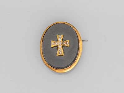 une broche en forme de croix en émail doré et noir, sertie de diamants