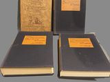three books sitting on top of each other on a gray surface