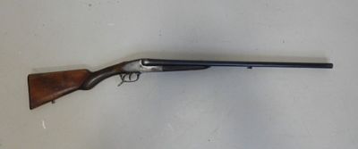 un fusil de chasse posé sur une table près d'un mur