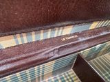 a brown suitcase with a yellow and blue checkered pattern