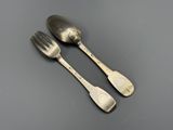deux cuillères en argent et une fourchette posées sur une table