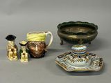 trois pièces de poterie sont posées sur une table à côté d'un bol