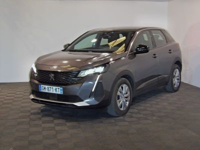 La voiture grise est garée dans le showroom, sur le sol à carreaux.