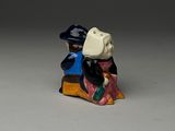 une figurine représentant un homme et une femme assis sur un banc