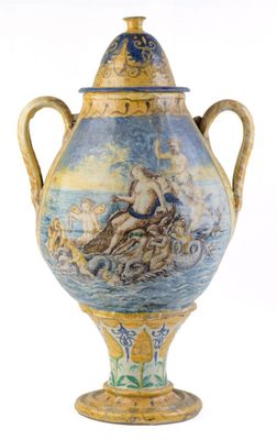un grand vase avec un tableau posé sur une table