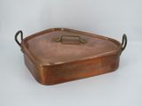 an old copper pan with a brass handle on a white background