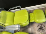 four green leather seats in a row on the floor