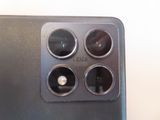 the back of a black cell phone with four camera lenses on it