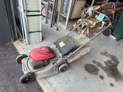 une tondeuse à gazon posée devant un garage