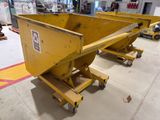 two large yellow dump trucks are parked in a warehouse