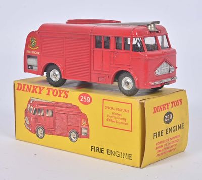 un camion de pompiers rouge en jouet posé sur une boîte jaune