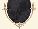 a black marble mirror on a gold stand