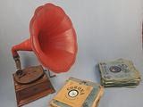 un gramophone rouge et une pile de livres à côté d'une pile de billets