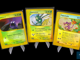 Trois cartes Pokémon sont représentées en ligne sur un fond noir