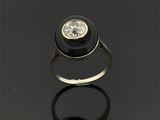 une bague en diamant noir et blanc posée sur une surface noire