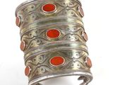 an image of a silver cuff with red stones on it