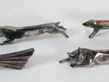 several metal animal figurines are displayed on a white surface