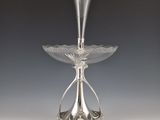 an antique silver plate with a flower design on it