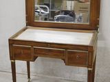 a small desk with a mirror on top of it