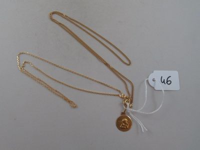 two gold necklaces with a gold coin on a white background