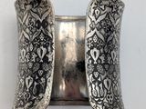 a close up of a silver cuff with a flower design on it