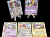 quatre types différents de cartes Pokémon exposées sur un fond noir