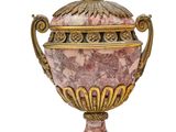 a pink and gold vase with a lid on a stand
