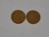 two gold coins on a white surface, one of them is a penny and the other is a penny