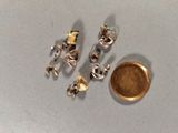 une pièce d'or à côté d'une boucle d'oreille en argent et en or
