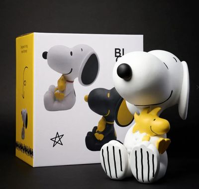 Figurine de Snoop et Woodstock dans une boîte sur fond noir et blanc