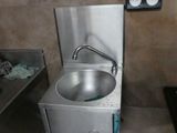 un lavabo en acier inoxydable dans une petite salle de bains