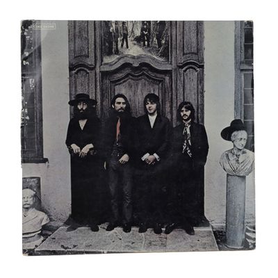 a black and white photo of a group of men sitting in front of a door