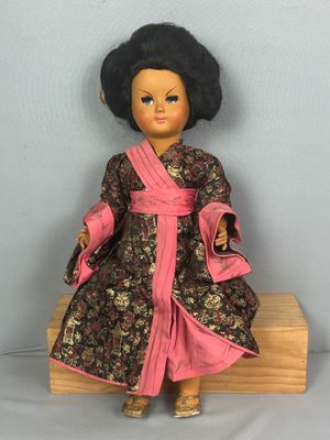 une image représentant une poupée aux cheveux noirs et vêtue d'une robe rose