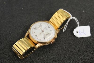 un gros plan d'une montre-bracelet posée sur une surface noire, avec une étiquette de prix