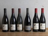 six bouteilles de vin sont alignées sur une table en bois