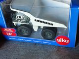 un camion miniature qui se trouve dans une boîte posée par terre