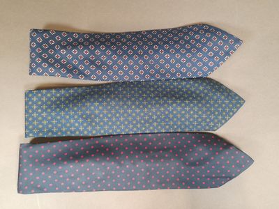 three different colored ties are lined up on a table